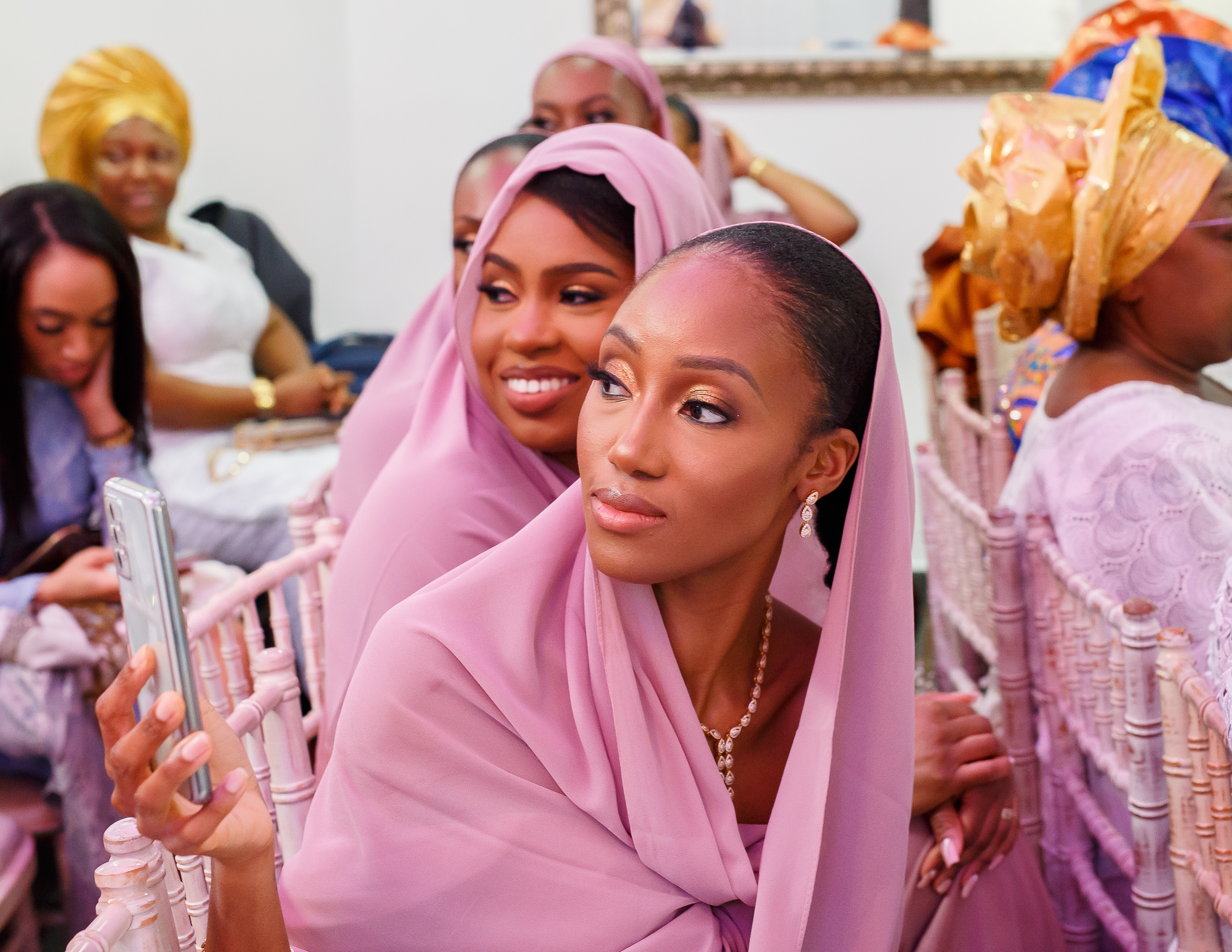 Nigerian Wedding DJ London Traditional with bridesmaid holding phone taking a picture wearing a hijab